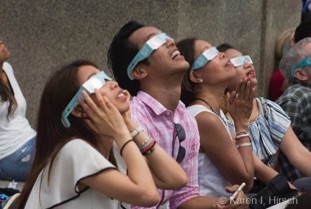 4 Asians looking up with eclipse glasses